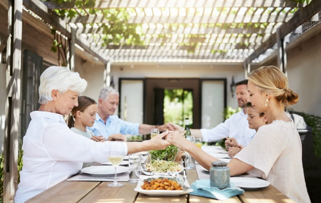 Shot of a family saying grace while sitting together at the dining table